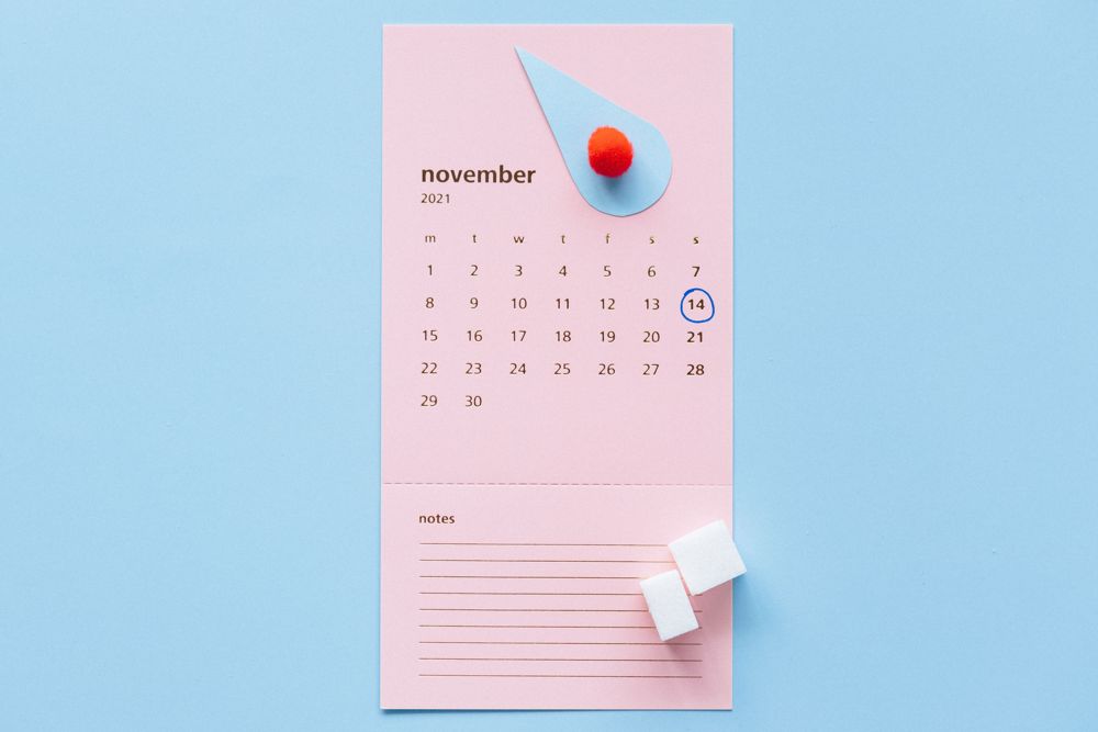 Calendar cu gămălie și cuburi de zahăr ilustrând urmărirea ciclului menstrual