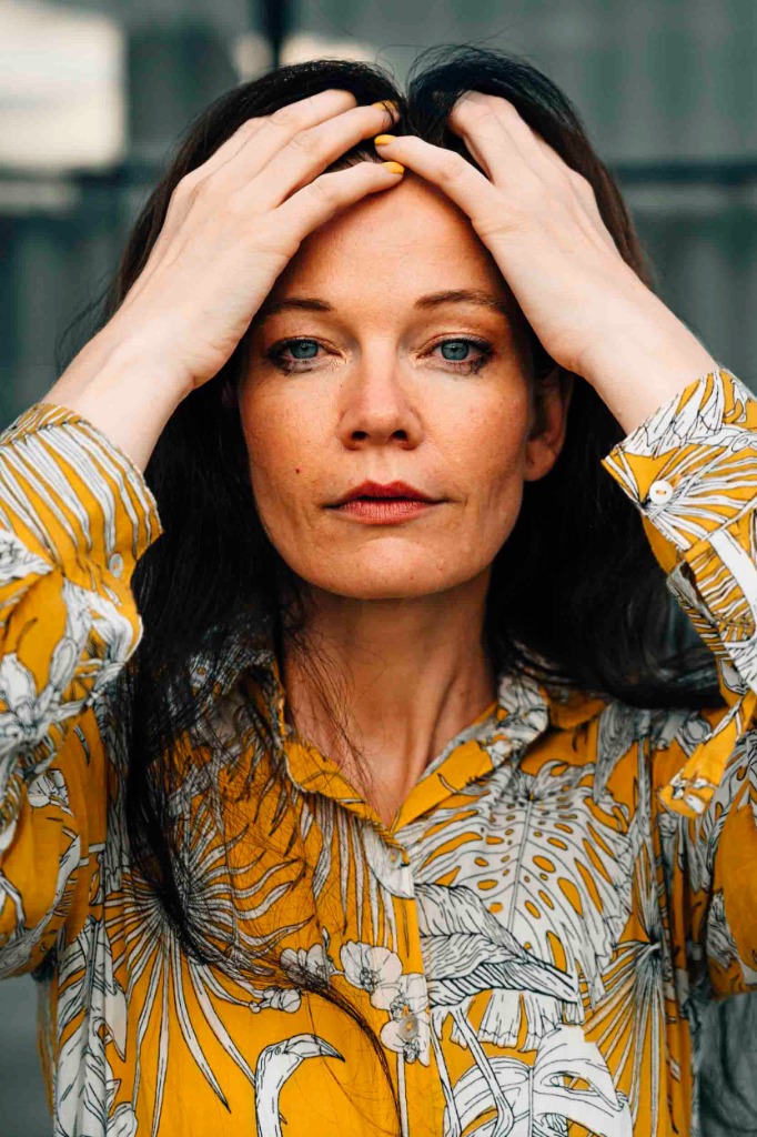 Woman holding her head due to perimenopause symptoms